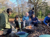a group of people sitting around a campfire
